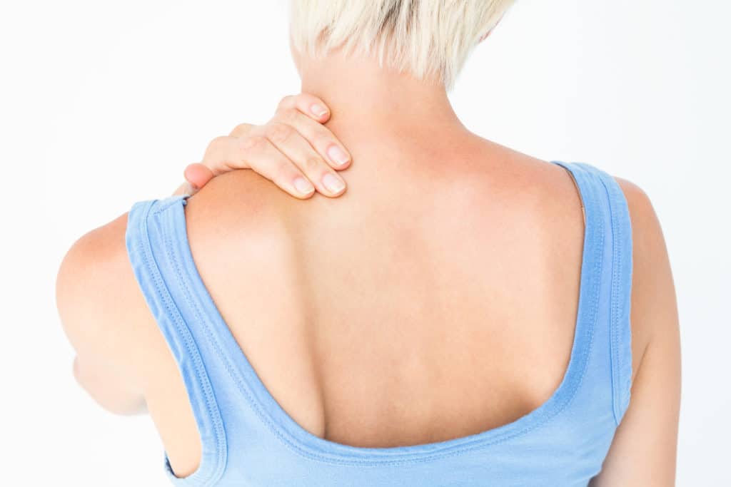 Casual woman with neck pain on white background