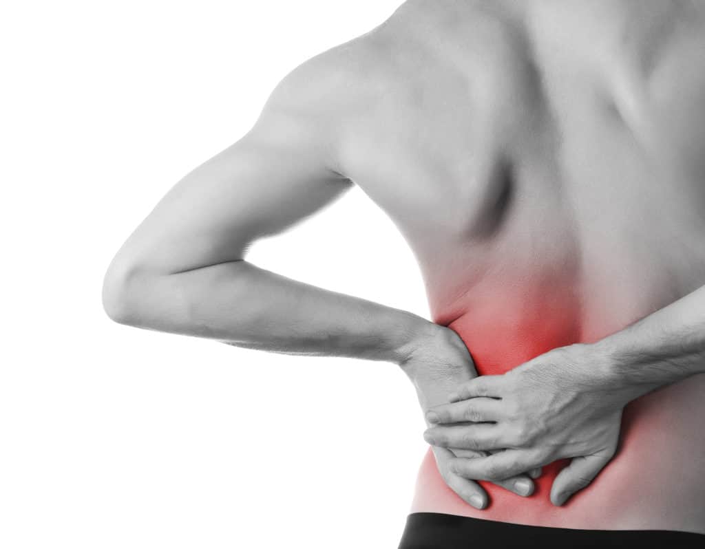 Rear view of a young man holding his back in pain caused by constipation